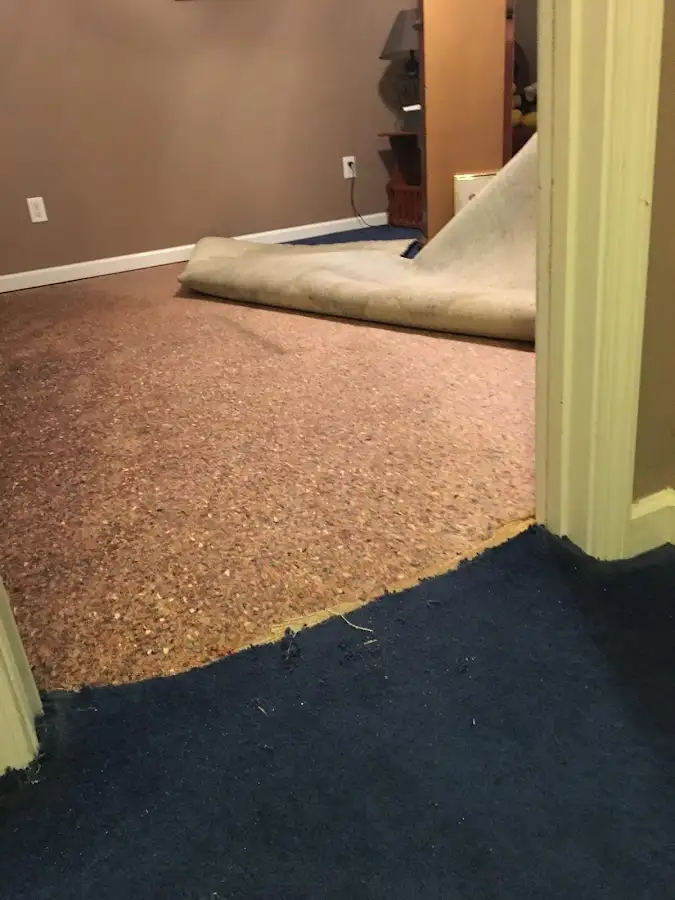 Carpet pad removal revealing water damage during Water Mitigation Services in Swainsboro